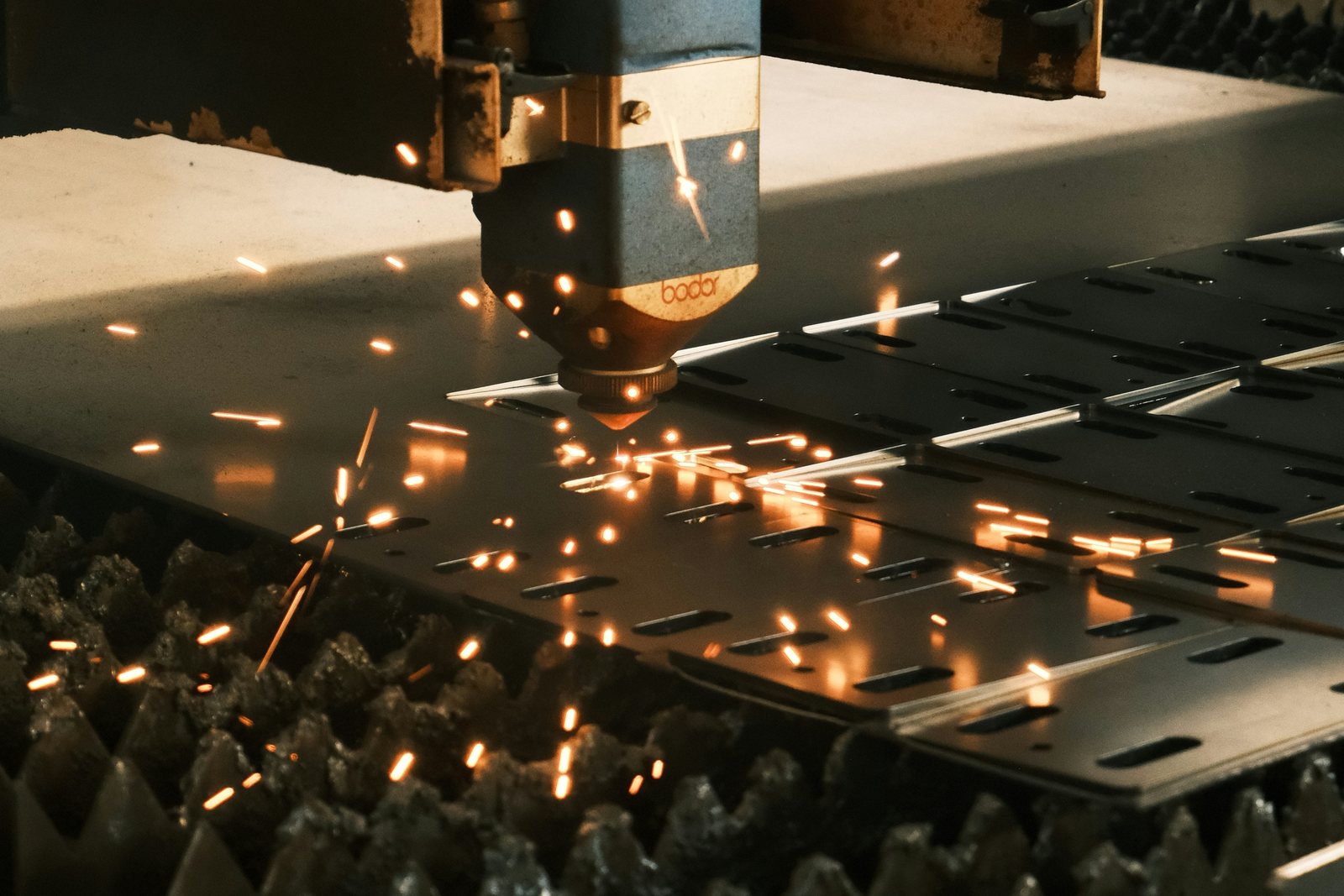 Laser cutting head cutting slots in steel sheet