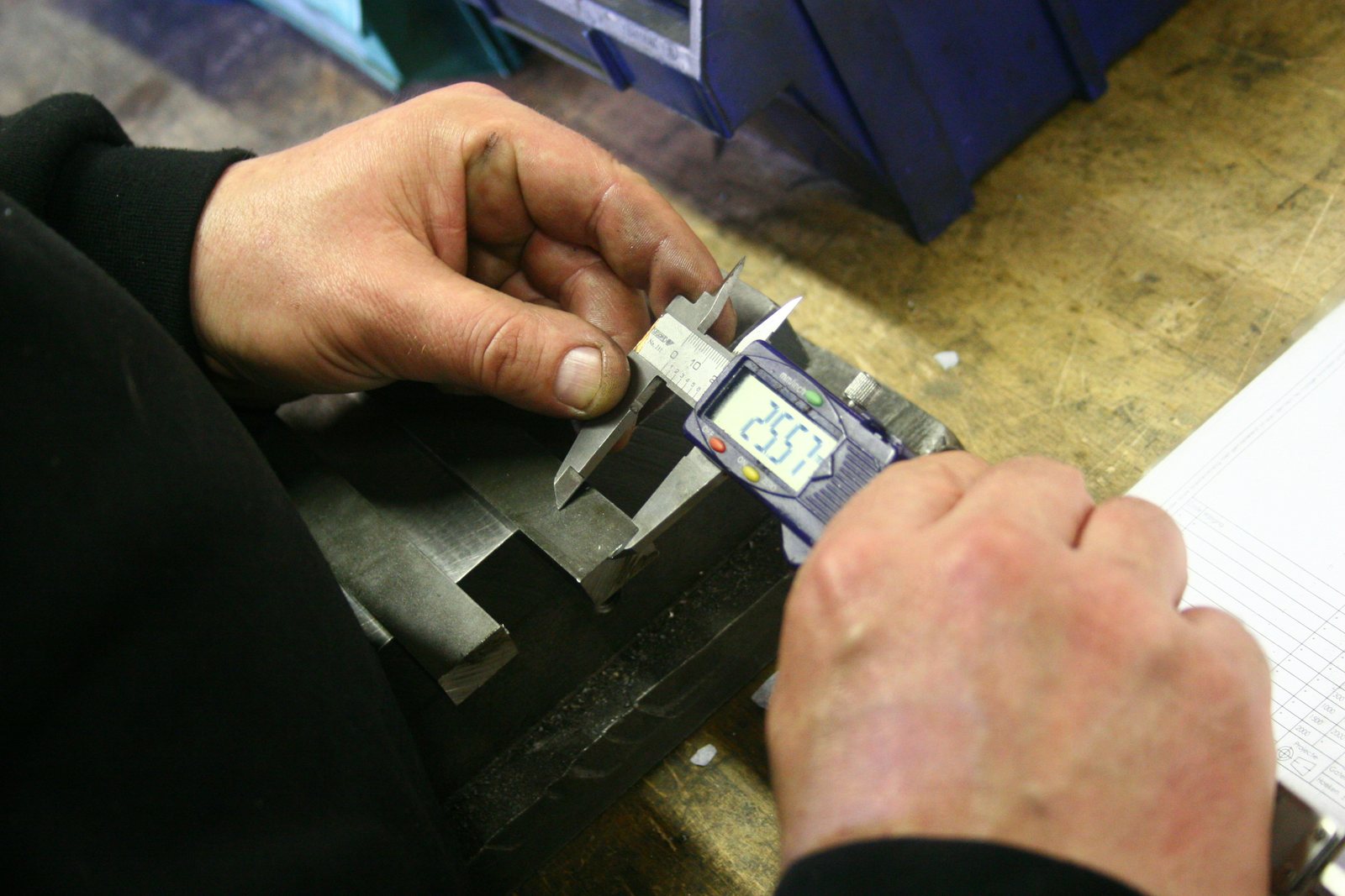 Digital caliper measuring a machined part during inspection