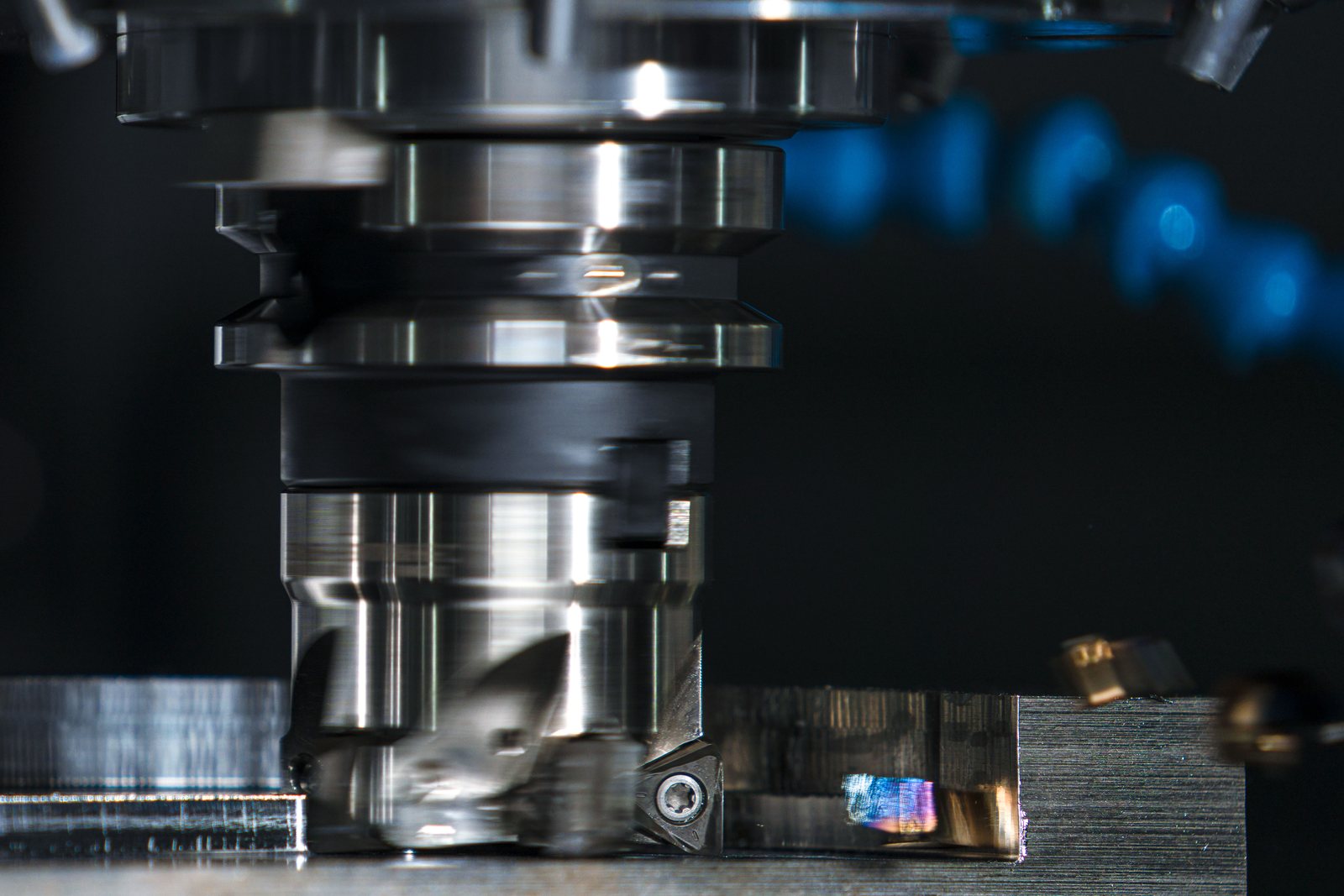 Face mill cutting a steel block on a milling machine