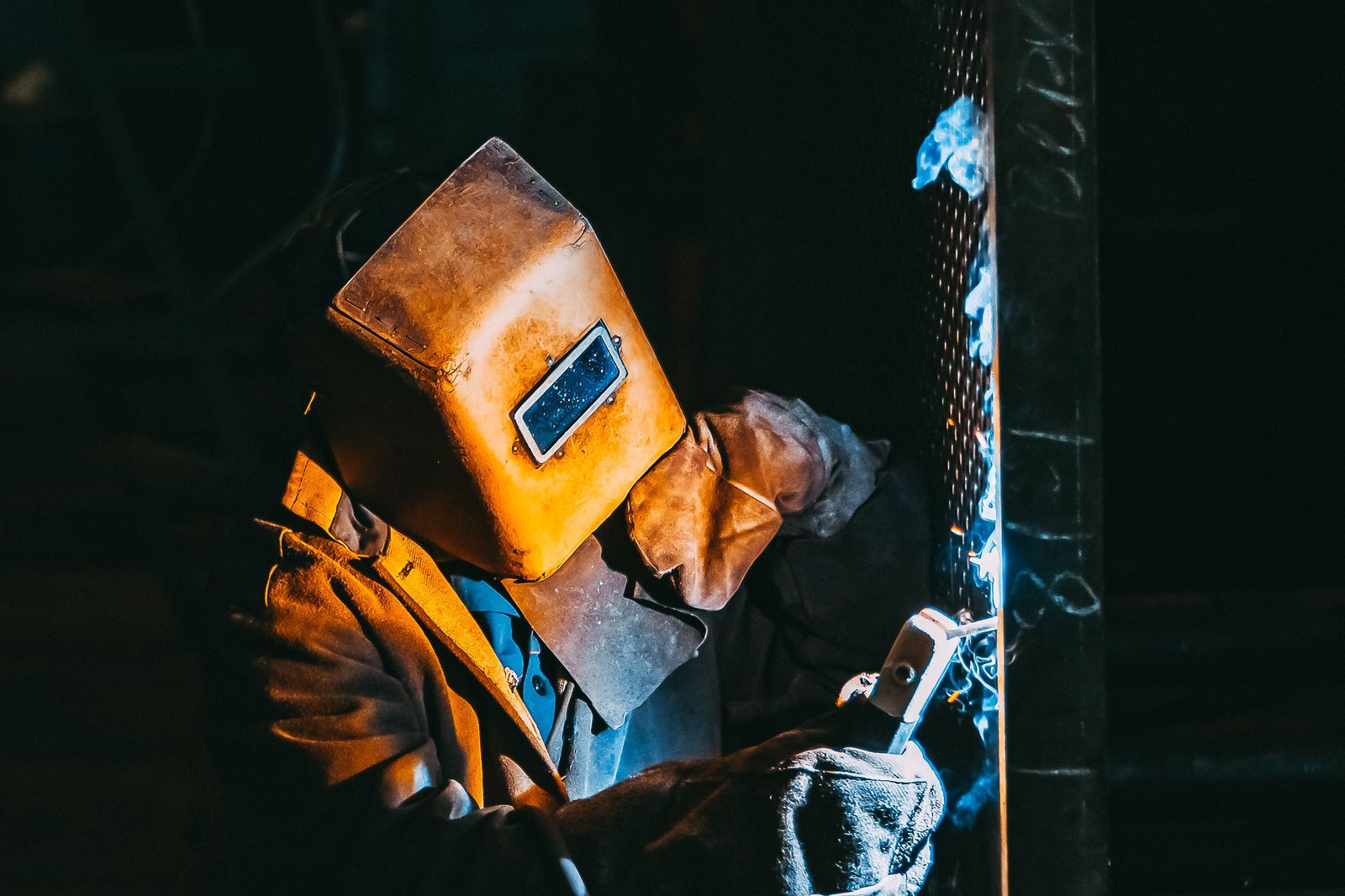 Precision welding: welder in protective gear joining steel